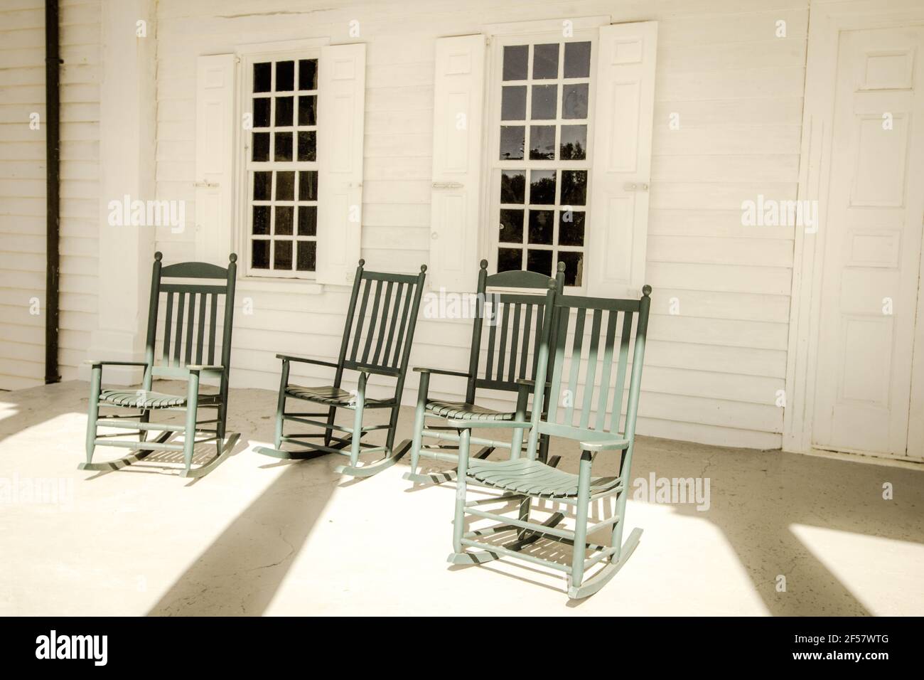 Group of empty rocking chairs on front porch. Stock Photo