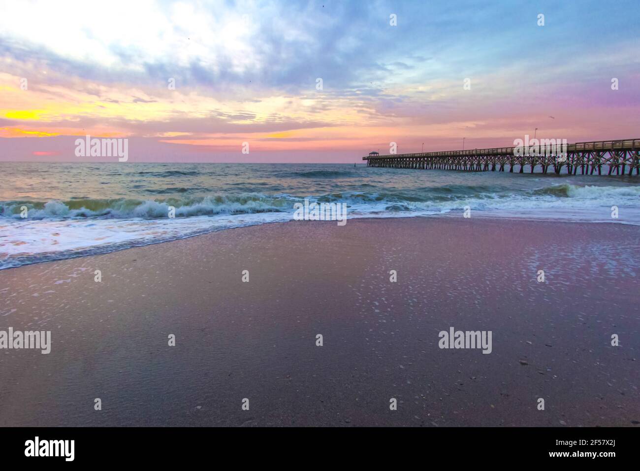 Myrtle Beach Sunrise Landscape. Sunrise on a wide sandy beach with fishing pier on the coast of the Atlantic Ocean in Myrtle Beach, South Carolina USA Stock Photo