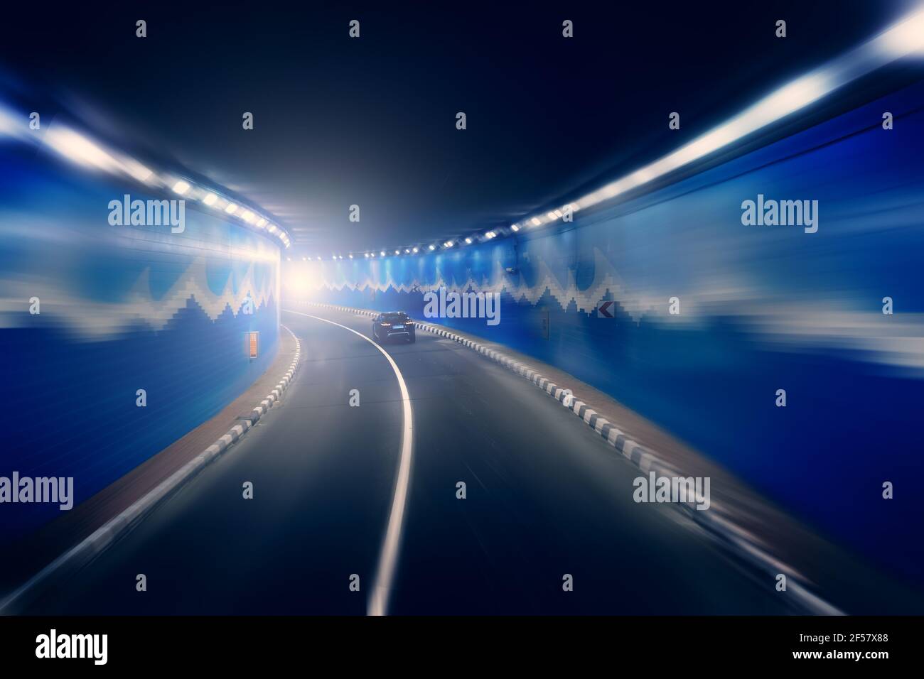 Road tunnel with riding car in blurred motion effect. Stock Photo