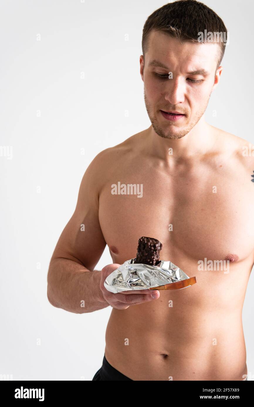 Man eats protein bar on white background isolated young eat, eating