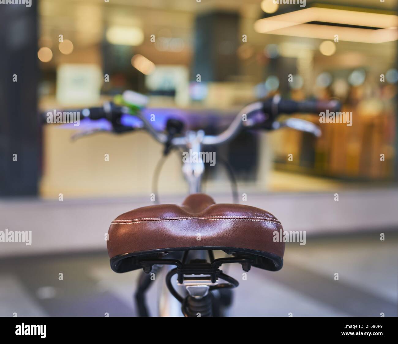detail of a rear view of a bicycle seat with handlebars out of focus Stock Photo