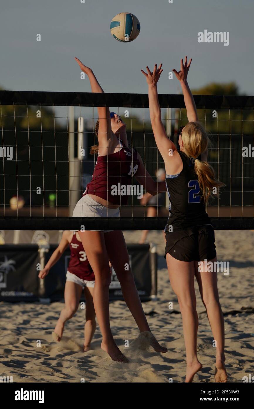 A tall blonde teenage girl competes in the sport of beach volleyball. Stock Photo