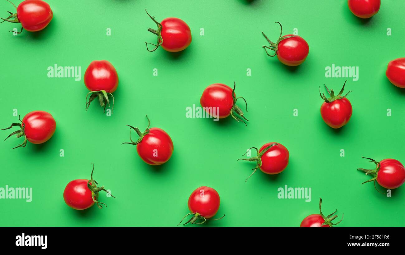 fresh red cherry tomatoes on green background, top view Stock Photo