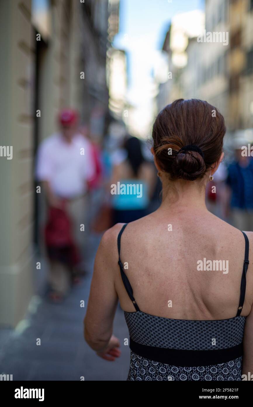 Back View Of a WomanTourist Walking Down A Busy Street In Florence, Italy Stock Photo