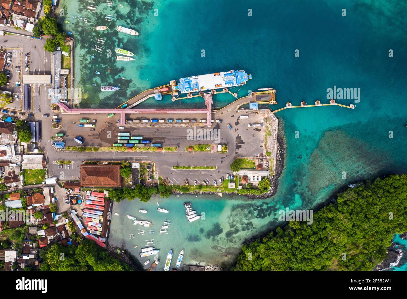 Top down view of the Padang Bai harbor in Bali, Indonesia, where trucks get out of a roro car ferry coming from Lombok Stock Photo