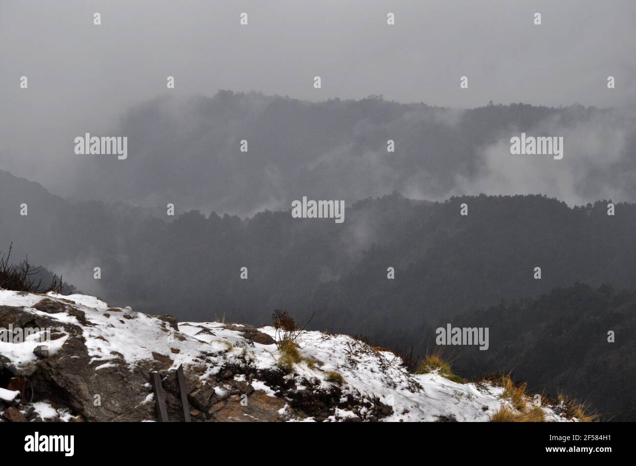 Rows of mountain ridges with silvery mist and cloud , background covered with snow Stock Photo