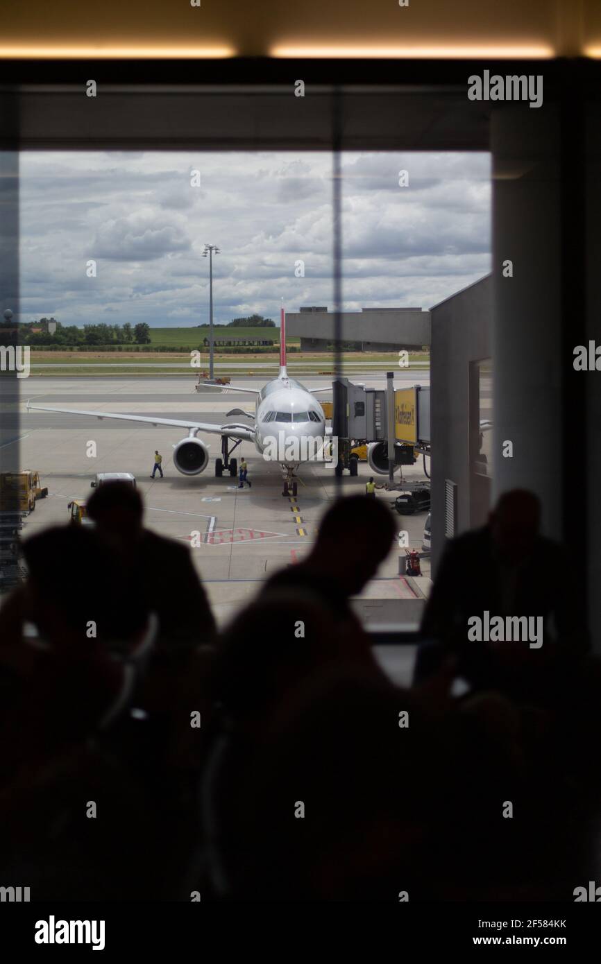 Silhouette Of People Queuing As Boarding An Airplane At An Airport Stock Photo