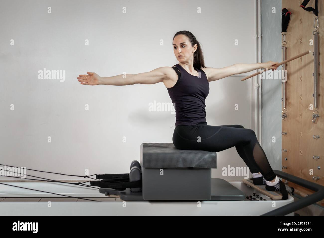 A woman doing pilates exercises on a reformed bed Stock Photo - Alamy