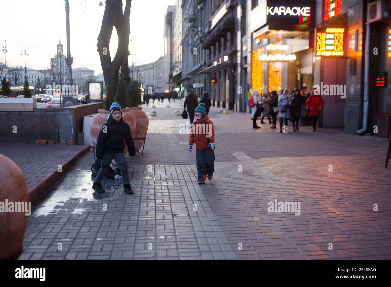 Two boys enjoy early winter day and ice on Khreschatyk street in downtown Kiev (Kyiv) the capital of Ukraine Stock Photo