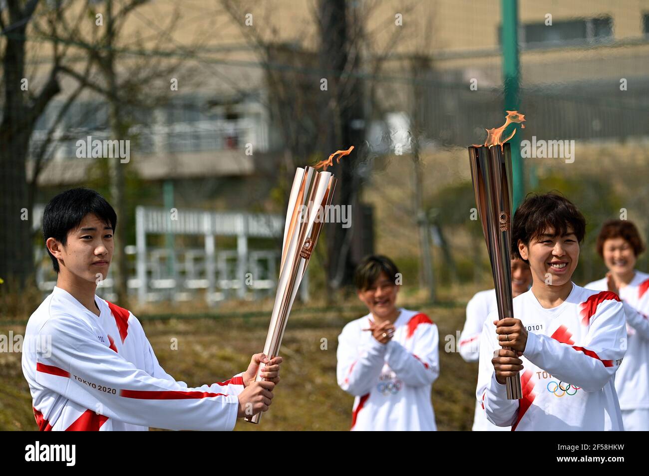FUKUSHIMA, March 25, 2021  Iwashimizu Azusa (R, front), former member of 'Nadeshiko Japan', the Japan women's National Football Team, and Japanese high school student Asato Owada are seen on the first day of the Tokyo 2020 Olympic torch relay in Futaba, Fukushima of Japan, on March 25, 2021. (Philip Fong/POOL via Xinhua) Stock Photo