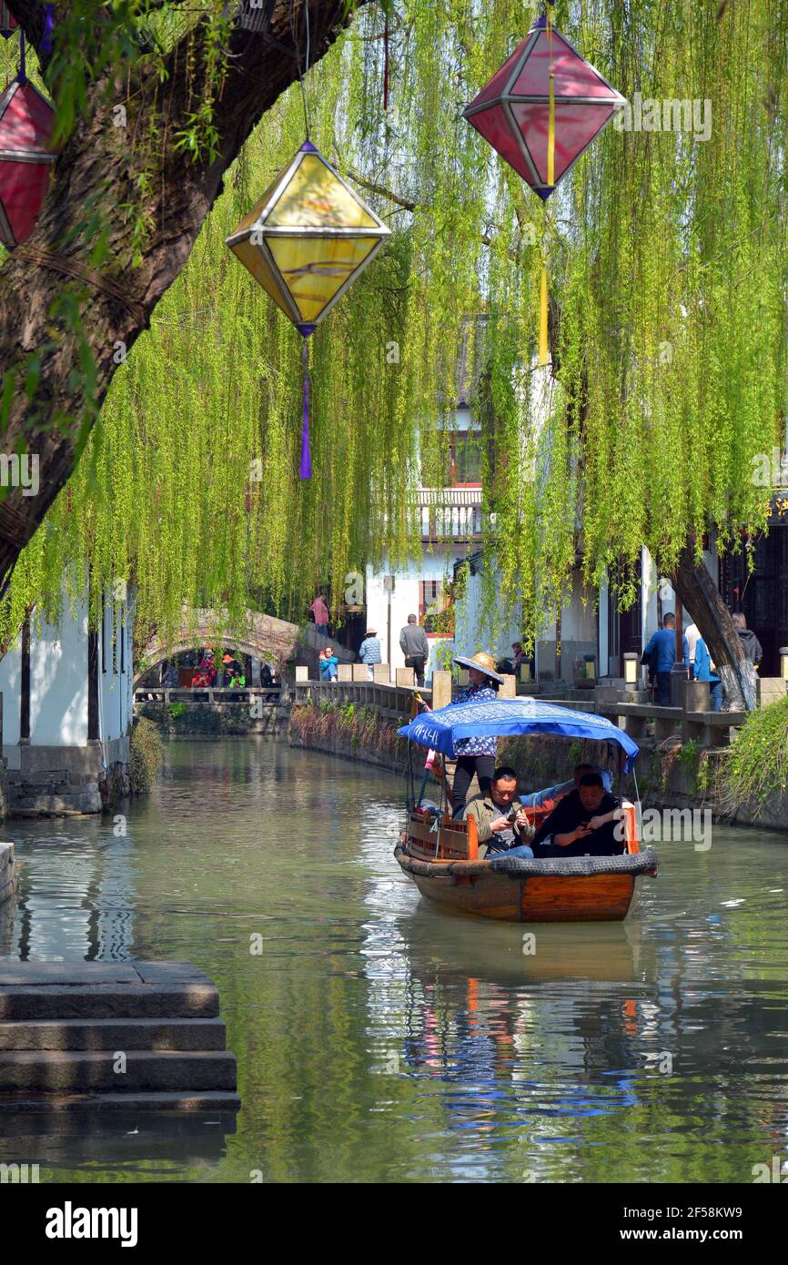 Tourists take a boat ride in the beautiful scenic area of Zhouzhuang but find their mobile phones more interesting. Stock Photo