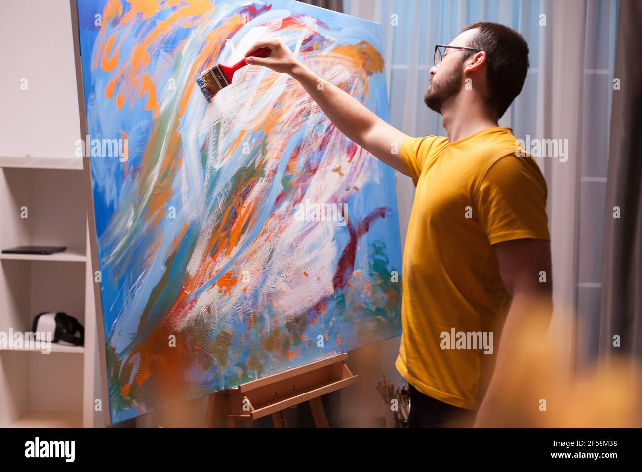 Man painting a masterpiece on large canvas in art studio. Modern ...