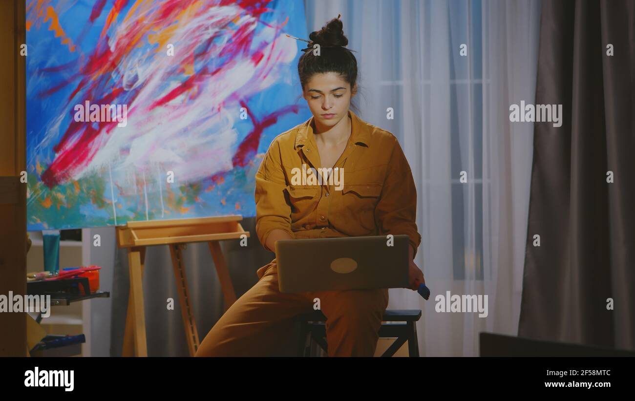 Find Artist Window Computer Painter searching inspiration on laptop in art studio Stock Photo - Alamy