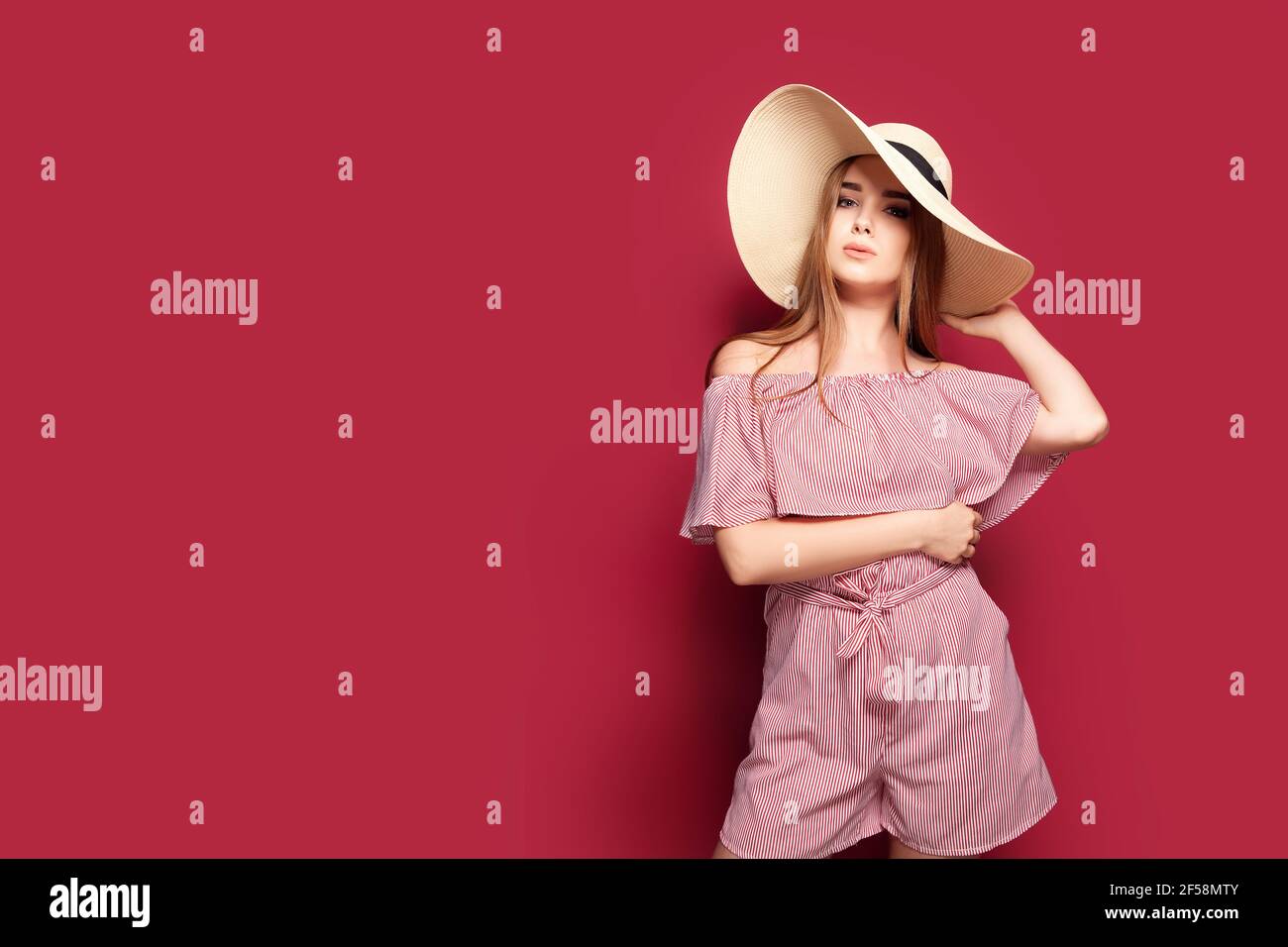 Beauty and fashion. Portrait of a gorgeous young woman in light red ...