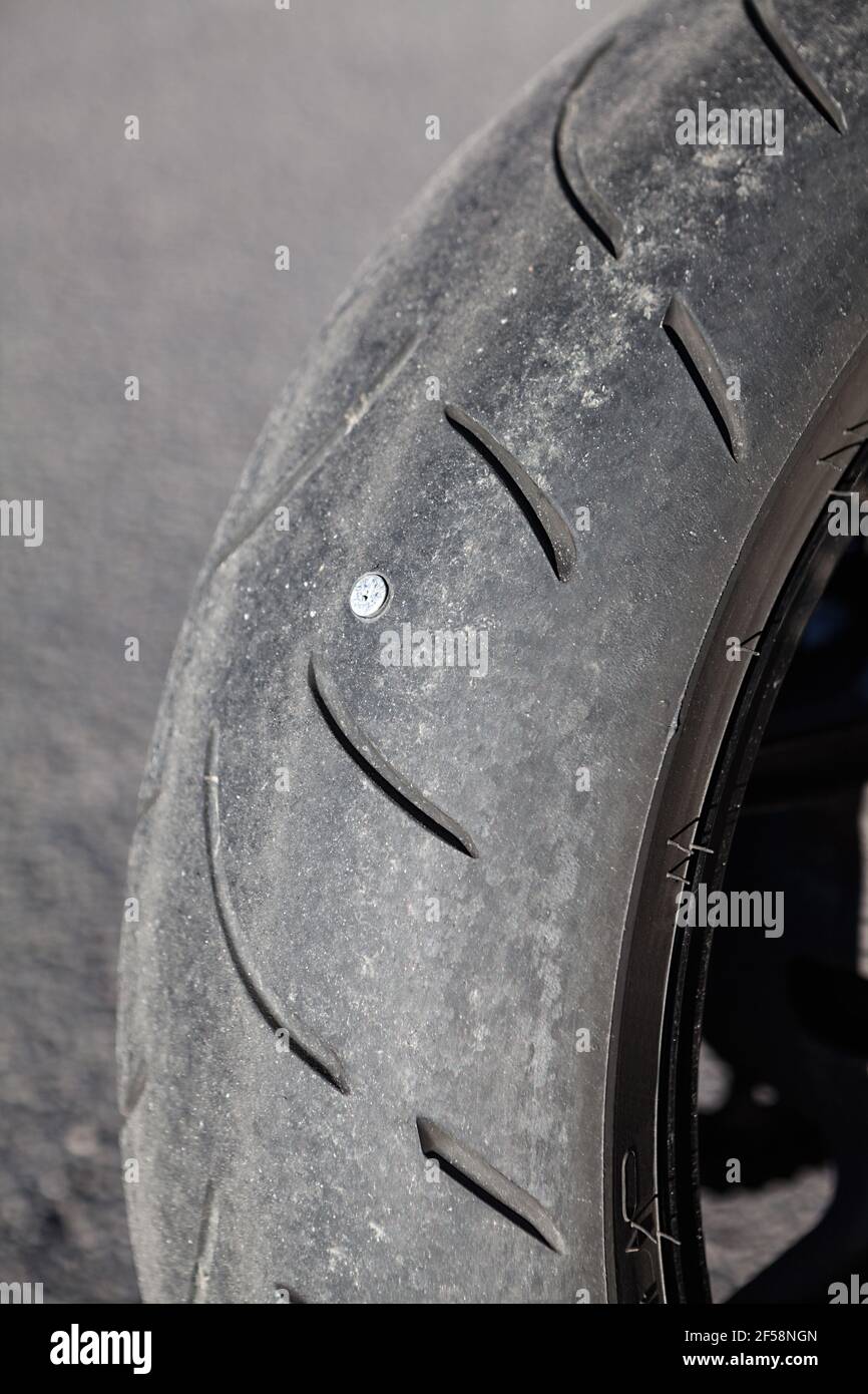 A small hole in a motorcycle tire resulting in an escape of air, close