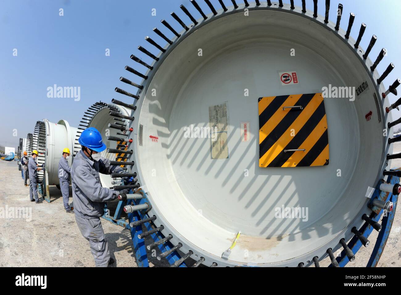 LIANYUNGANG, CHINA - MARCH 25, 2021 - Workers conduct a production operation at a production workshop of national  United Power Technology (Lianyungang) Co., Ltd in Lianyungang, Jiangsu province, China, March 25, 2021. national United Power Technology (Lianyungang) Co., Ltd. continues to carry out product upgrading and innovation, and invests in R&D, manufacturing, sales and commissioning projects of 8-15MW offshore wind turbine and 3.X-5.X onshore large wind turbine. Up to now, the output has increased by 92% compared with the same period last year. (Photo by Wang Chun / Costfoto/Sipa USA) Stock Photo