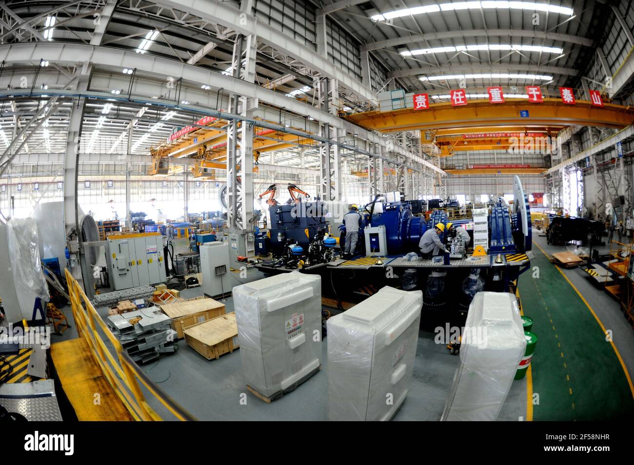 LIANYUNGANG, CHINA - MARCH 25, 2021 - Workers conduct a production operation at a production workshop of national  United Power Technology (Lianyungang) Co., Ltd in Lianyungang, Jiangsu province, China, March 25, 2021. national United Power Technology (Lianyungang) Co., Ltd. continues to carry out product upgrading and innovation, and invests in R&D, manufacturing, sales and commissioning projects of 8-15MW offshore wind turbine and 3.X-5.X onshore large wind turbine. Up to now, the output has increased by 92% compared with the same period last year. (Photo by Wang Chun / Costfoto/Sipa USA) Stock Photo