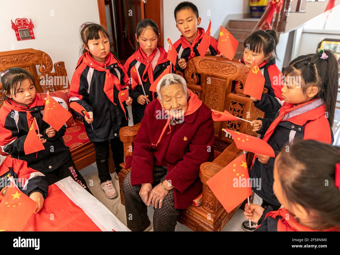 HAI'AN, CHINA - MARCH 25, 2021 - Primary school students listen to Gu Guangying, a veteran Communist Party member before the founding of the People's Republic of China, tell stories about the Anti-Japanese War in Hai 'an, east China's Jiangsu Province, March 25, 2021. (Photo by Zhai Huiyong / Costfoto/Sipa USA) Credit: Sipa USA/Alamy Live News Stock Photo