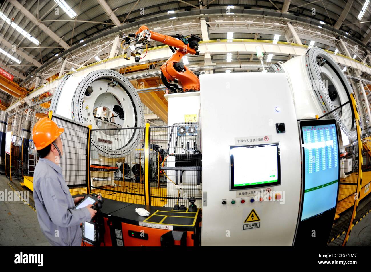 LIANYUNGANG, CHINA - MARCH 25, 2021 - A worker conducts a production operation at a production workshop of national  United Power Technology (Lianyungang) Co., Ltd in Lianyungang, Jiangsu province, China, March 25, 2021. national United Power Technology (Lianyungang) Co., Ltd. continues to carry out product upgrading and innovation, and invests in R&D, manufacturing, sales and commissioning projects of 8-15MW offshore wind turbine and 3.X-5.X onshore large wind turbine. Up to now, the output has increased by 92% compared with the same period last year. (Photo by Wang Chun / Costfoto/Sipa USA) Stock Photo
