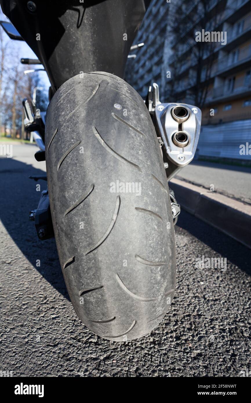 Motorcycle with screw nail in rear tire standing on stand. City road