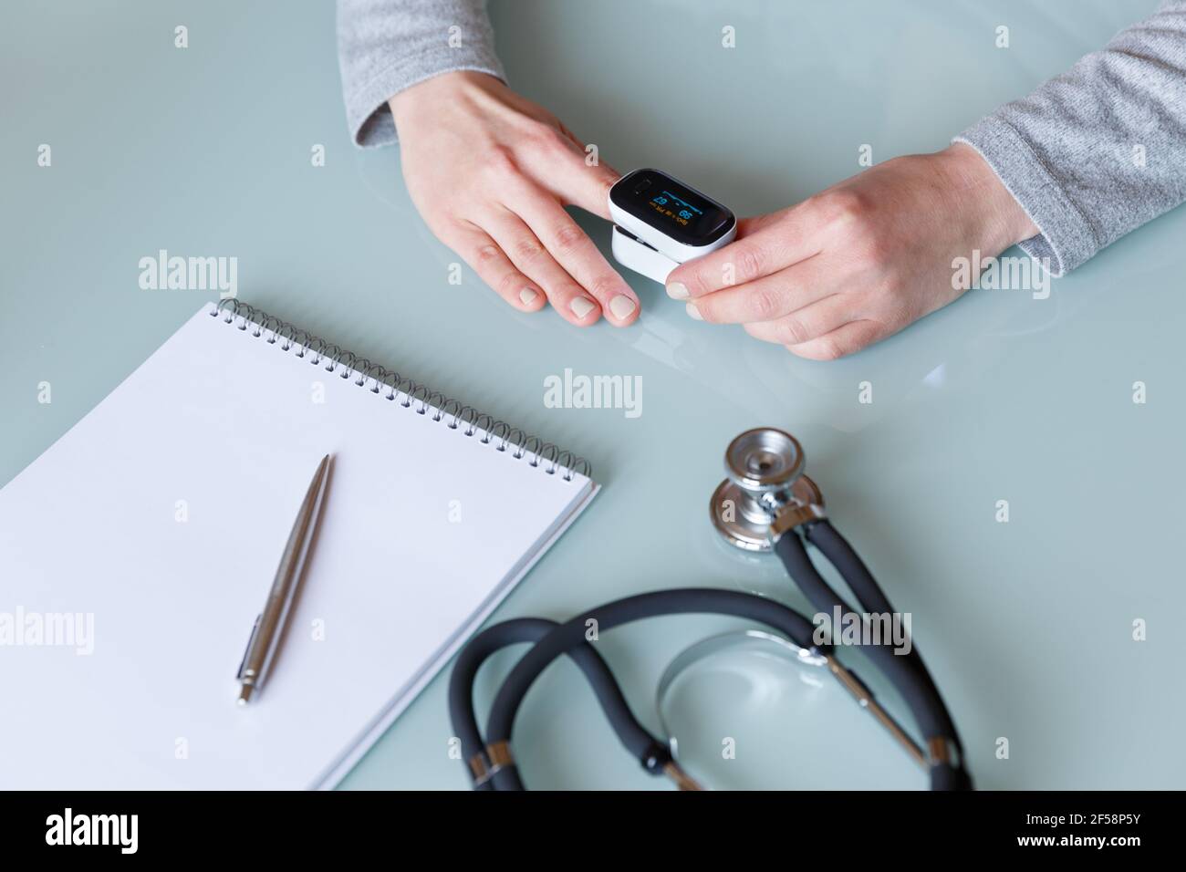 Female patient hand measuring oxygen saturation and pulse using portable oximeter. Health care concept Stock Photo