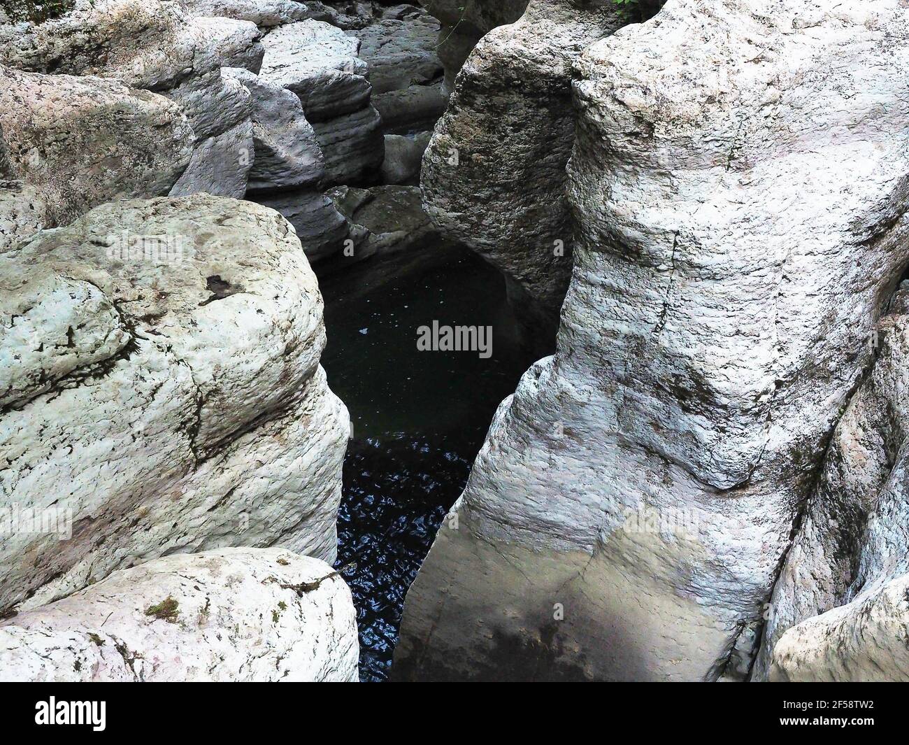Light hilly rocks with green clear water in gorge. Canyon white cliffs ...