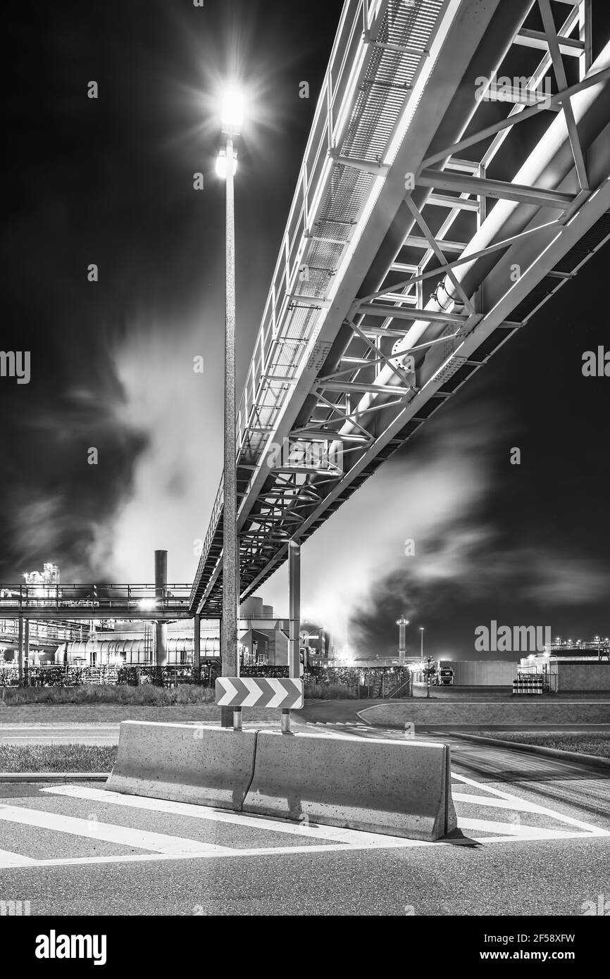 Night scene with illuminated petrochemical production plant and pipeline bridge, Antwerp, Belgium. Stock Photo