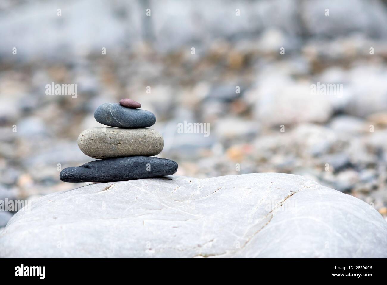 A background of pebbles by the ocean on the beach with copy space, a symbol of peace and relaxation. Stock Photo