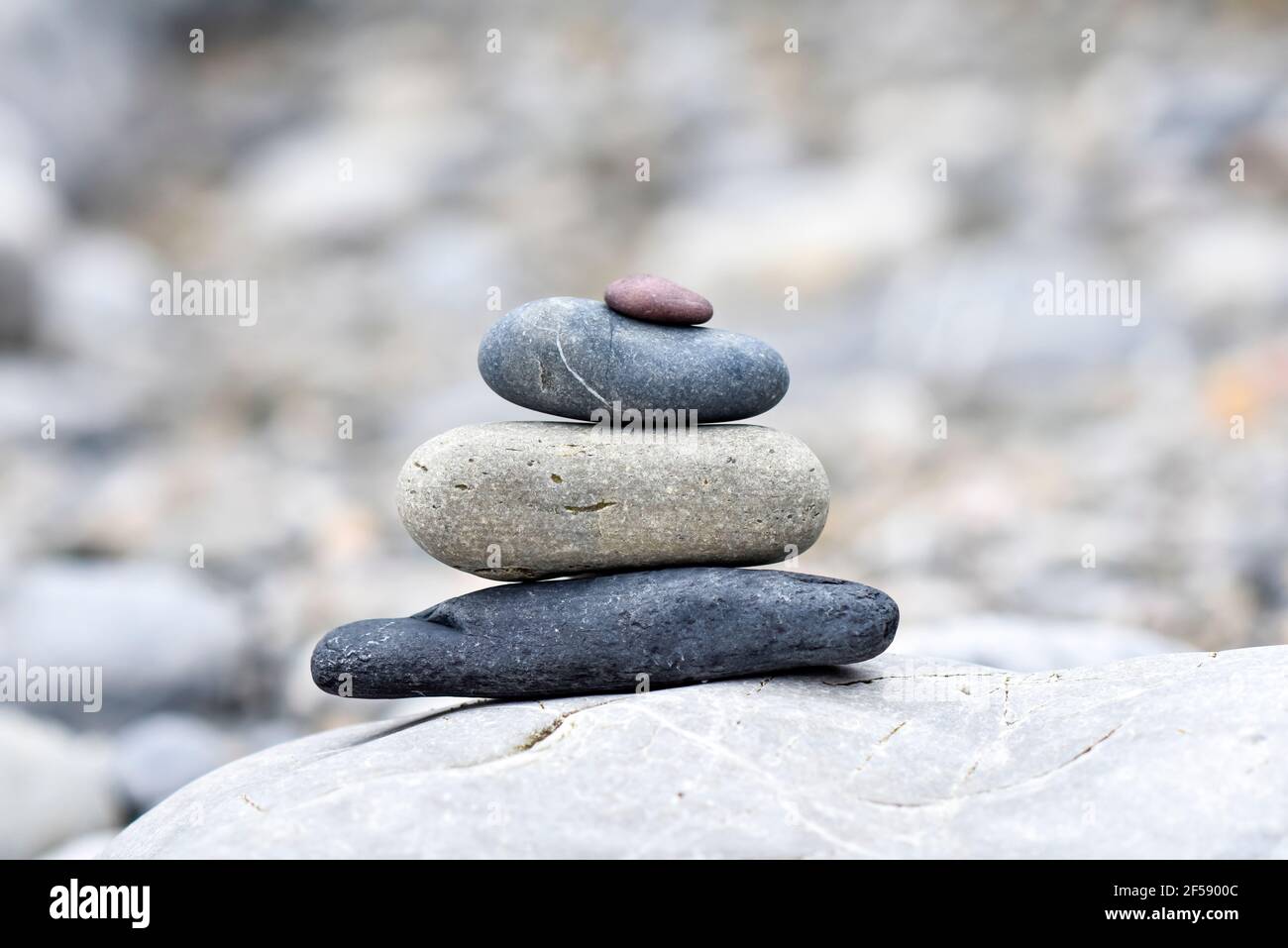 A background of pebbles by the ocean on the beach, a symbol of peace and relaxation. Stock Photo