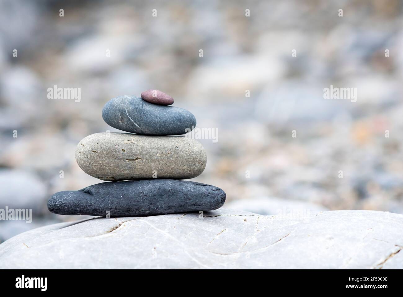A background of pebbles by the ocean on the beach with copy space, a symbol of peace and relaxation. Stock Photo