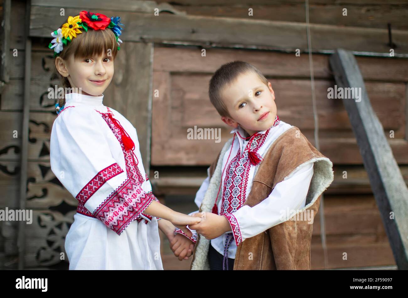 Little Boy And Girl In Slavic National Clothes On A Wooden Background Little Boy And Girl In Slavic National Clothes On A Wooden Background