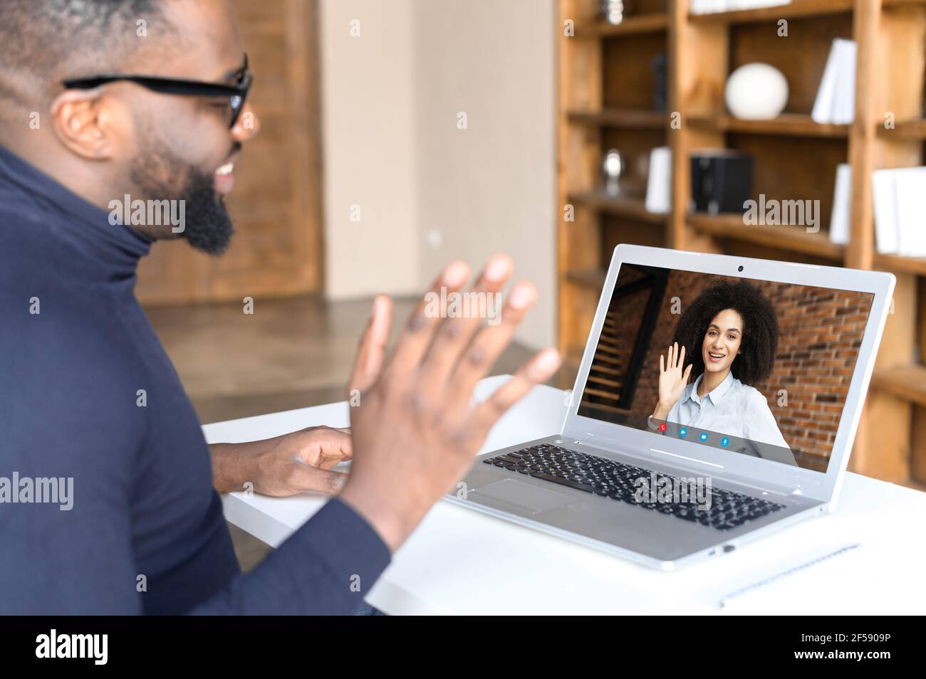 Back view of African-American man making video call with his female ...