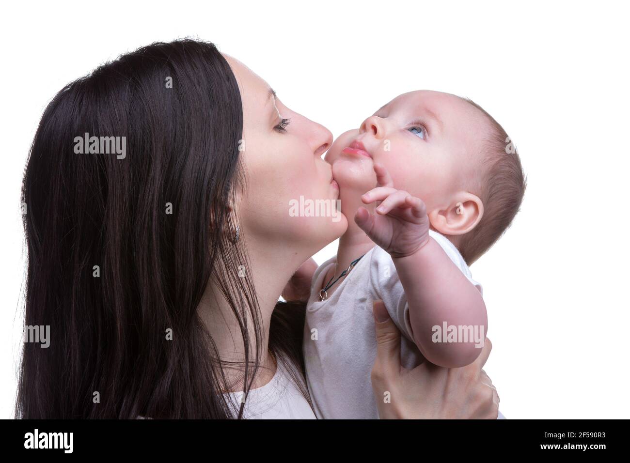 Mom kisses her little son on a light background. Motherhood. Stock Photo