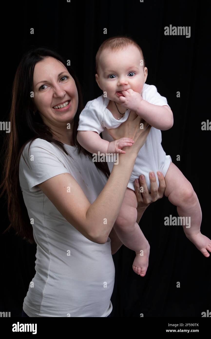 Mom and little son on a dark background. Motherhood. Stock Photo