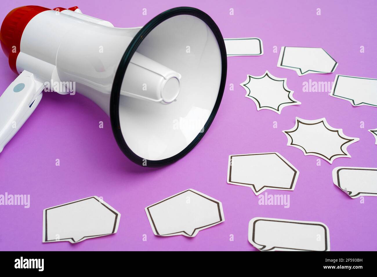 Electronic megaphone and speech bubble on purple background Stock Photo ...
