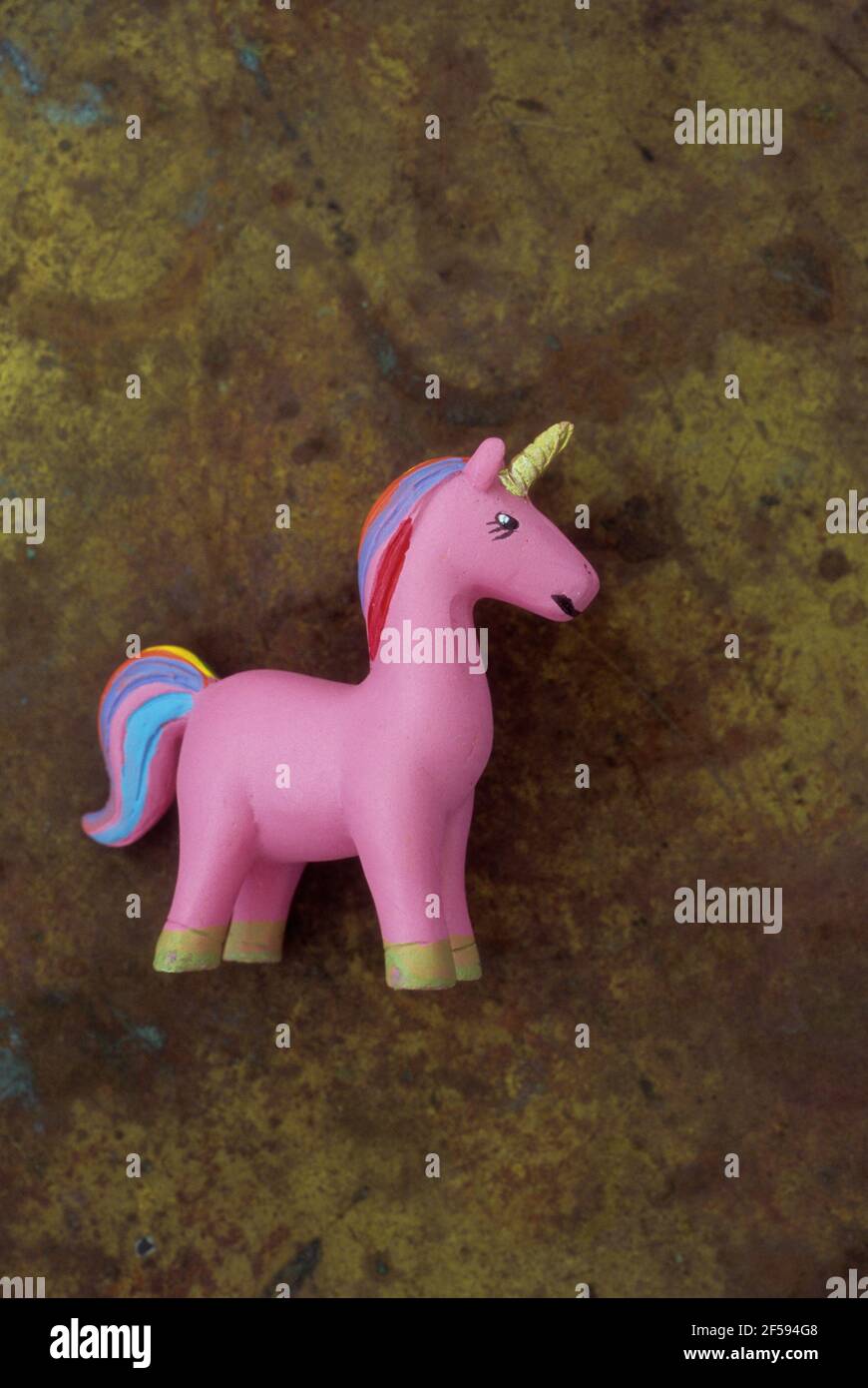 Model of pink unicorn with rainbow tail and mane and gold horn Stock Photo