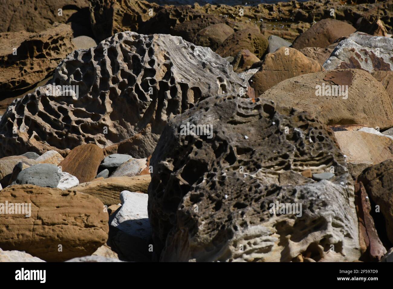 Closeup of the giant colorful rocks with holes on the beach on the ...