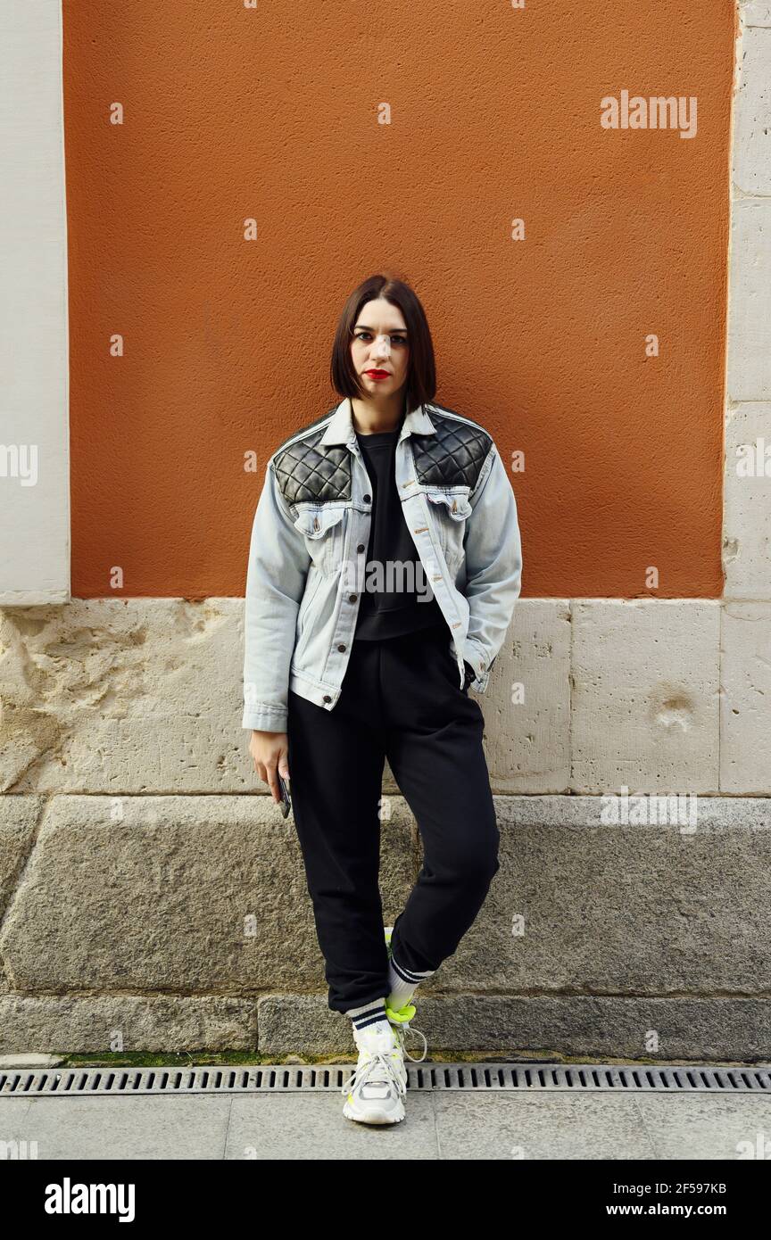 Young Spanish female with a bob style haircut wearing a bomber denim jacket and black pants Stock Photo