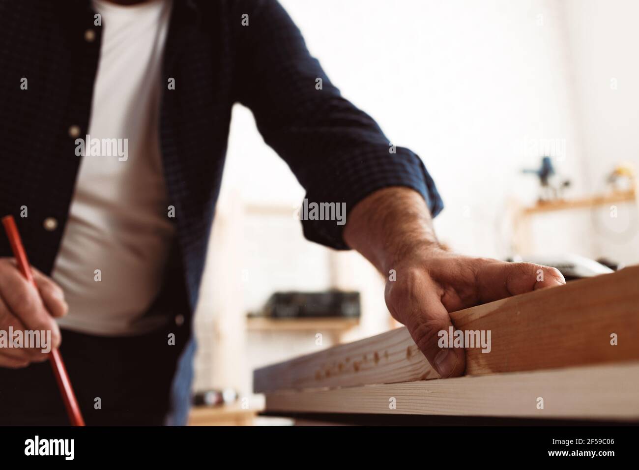 Carpenter makes pencil marks on a wood plank Stock Photo Alamy