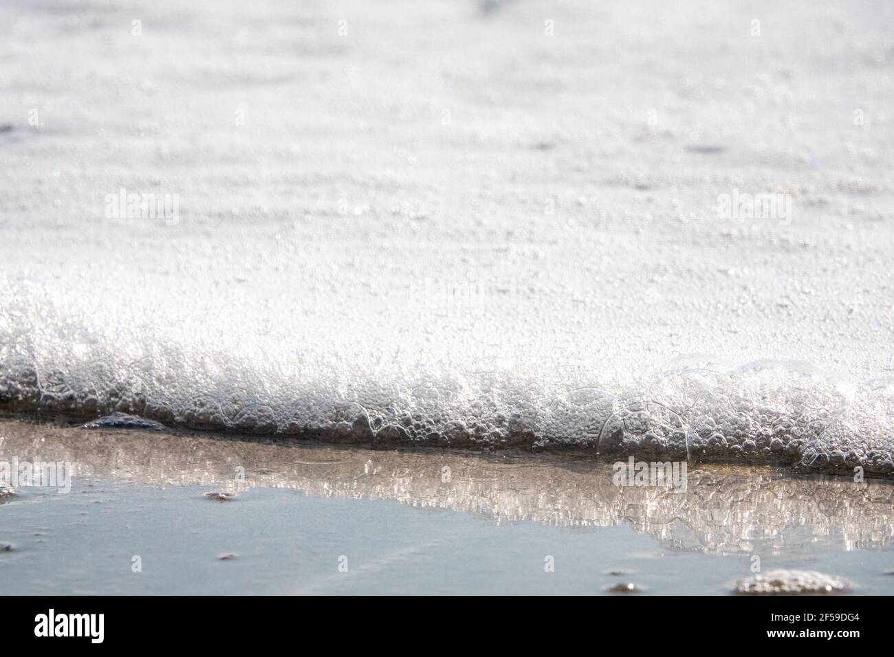 Beautiful shot of foam waves hitting the sandy seashore Stock Photo - Alamy