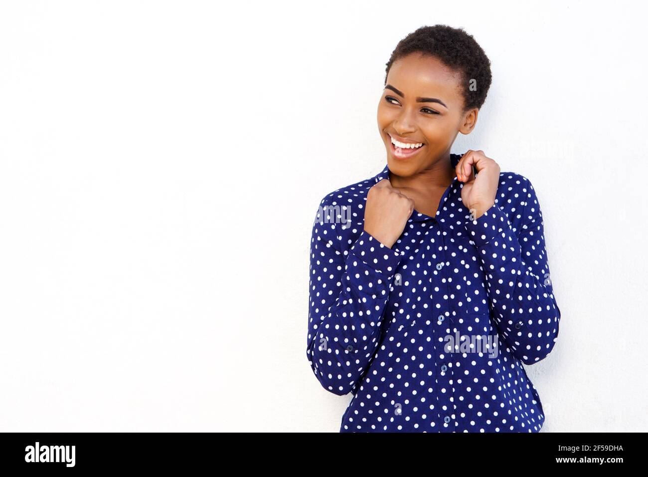 Portrait of young black woman smiling against isolated white background ...