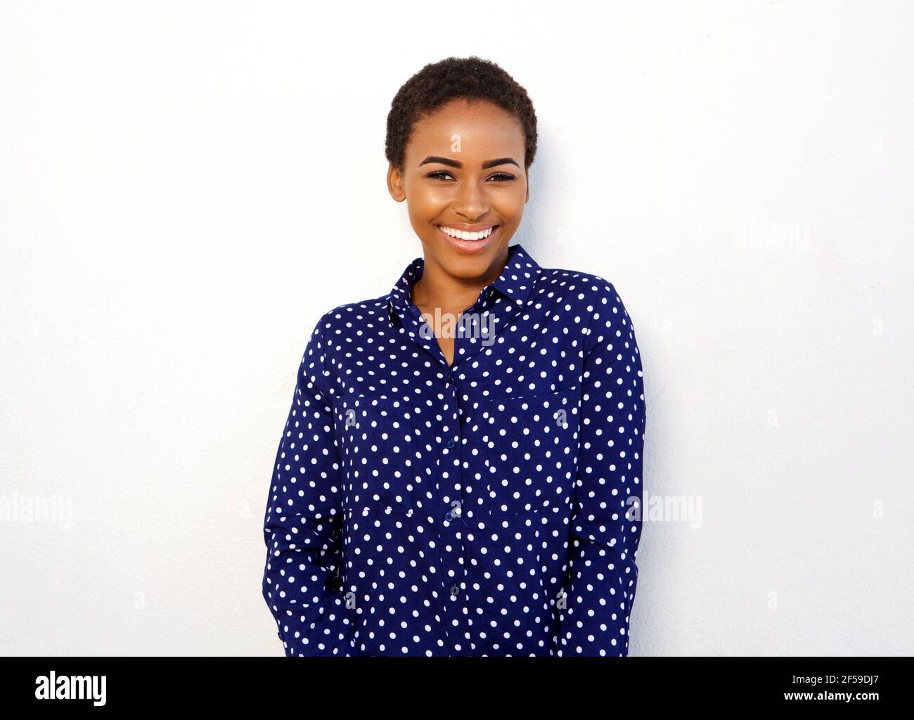 Portrait of attractive young black woman smiling against isolated white ...