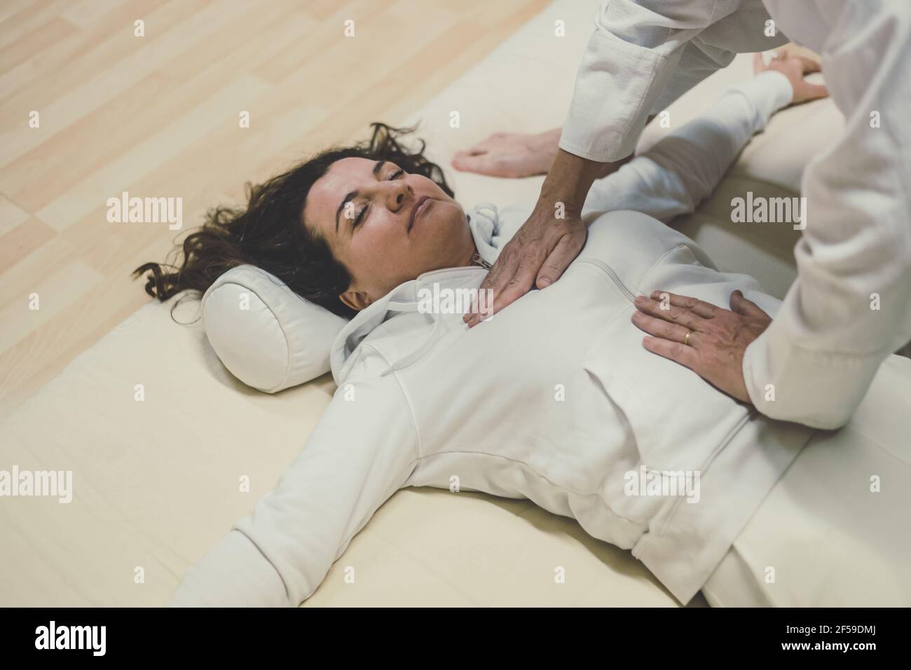 Therapist man doing a Shiatsu massage to a woman. Holistic therapy