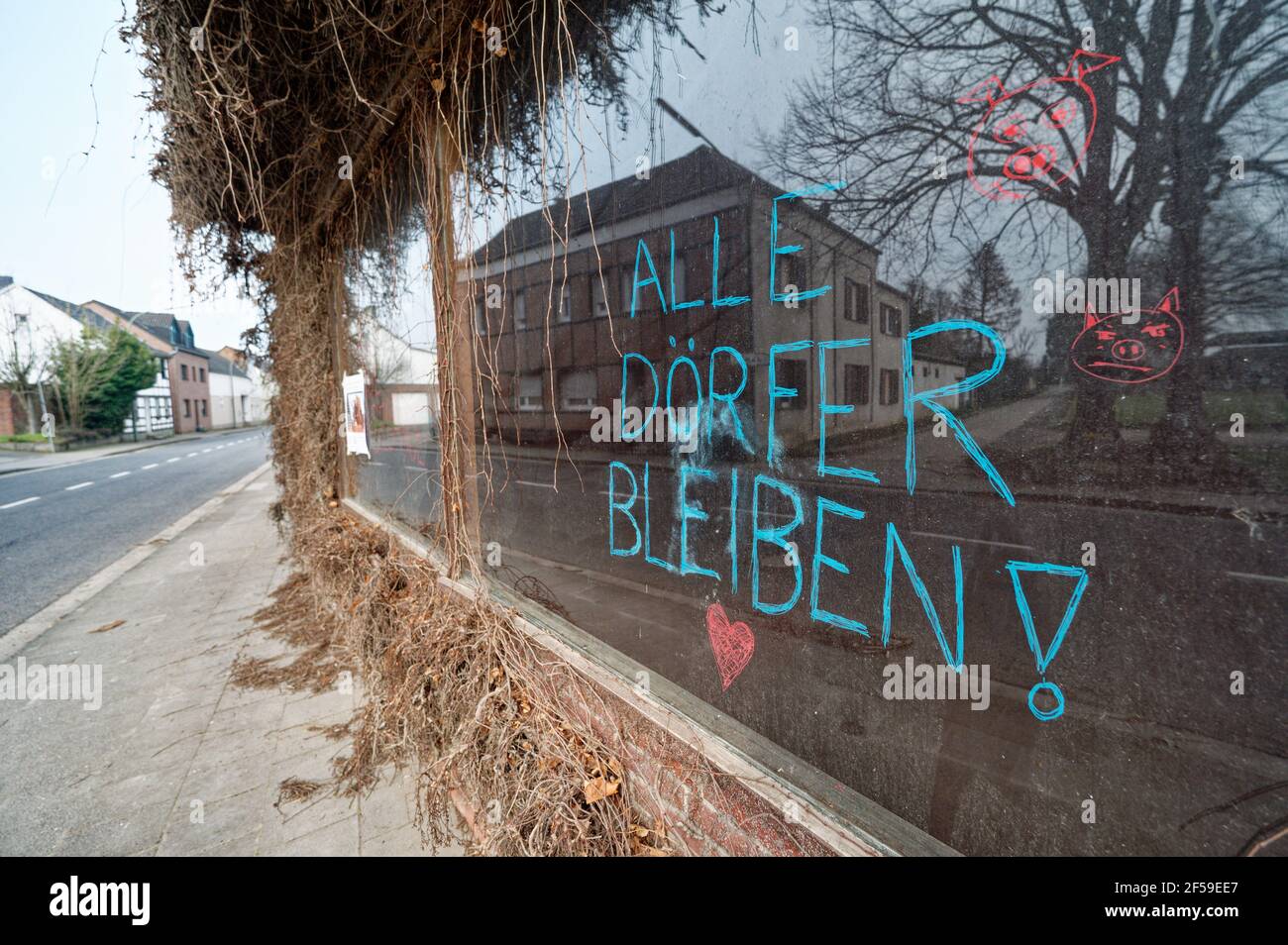 25 March 2021, North Rhine-Westphalia, Keyenberg: The words 'All villages stay' are written on a window pane in the village of Keyenberg, which is to make way for the Garzweiler opencast lignite mine.      (to dpa 'Lignite decision: government wants new jobs') Photo: Henning Kaiser/dpa Stock Photo