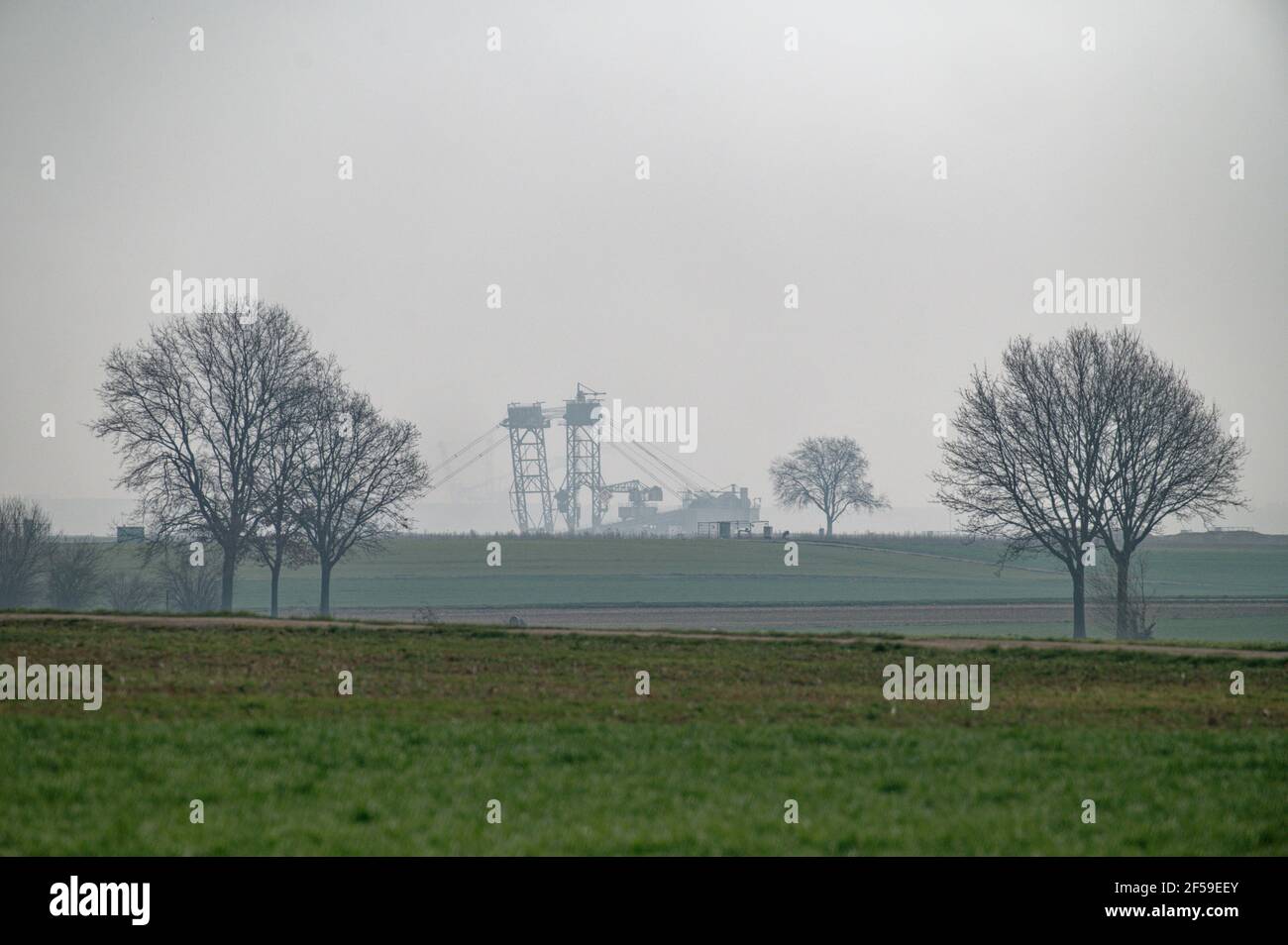 25 March 2021, North Rhine-Westphalia, Unterwestrich: A lignite excavator can be seen on the horizon near the village of Unterwestrich, which is to make way for the Garzweiler opencast lignite mine.      (to dpa 'Lignite decision: Government wants new jobs') Photo: Henning Kaiser/dpa Stock Photo