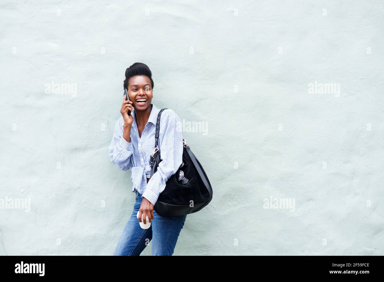 Portrait of young black woman laughing and talking on cellphone Stock ...