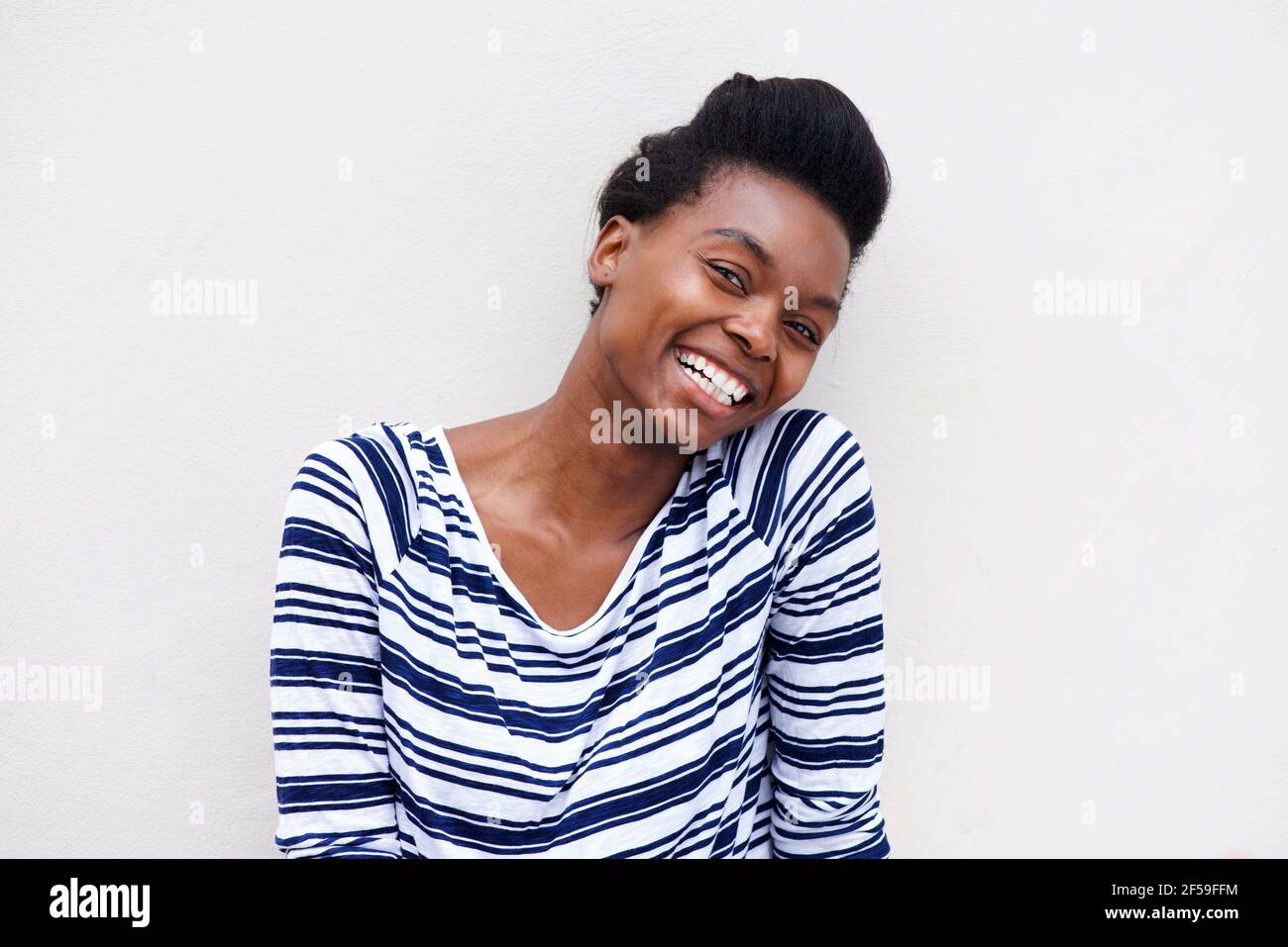 Close up portrait of african american woman laughing against white ...