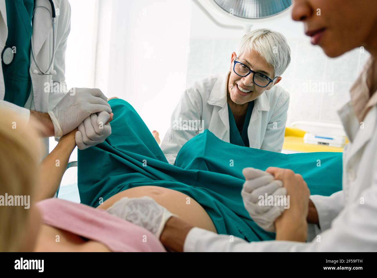 Woman giving birth in labor room of hospital Stock Photo