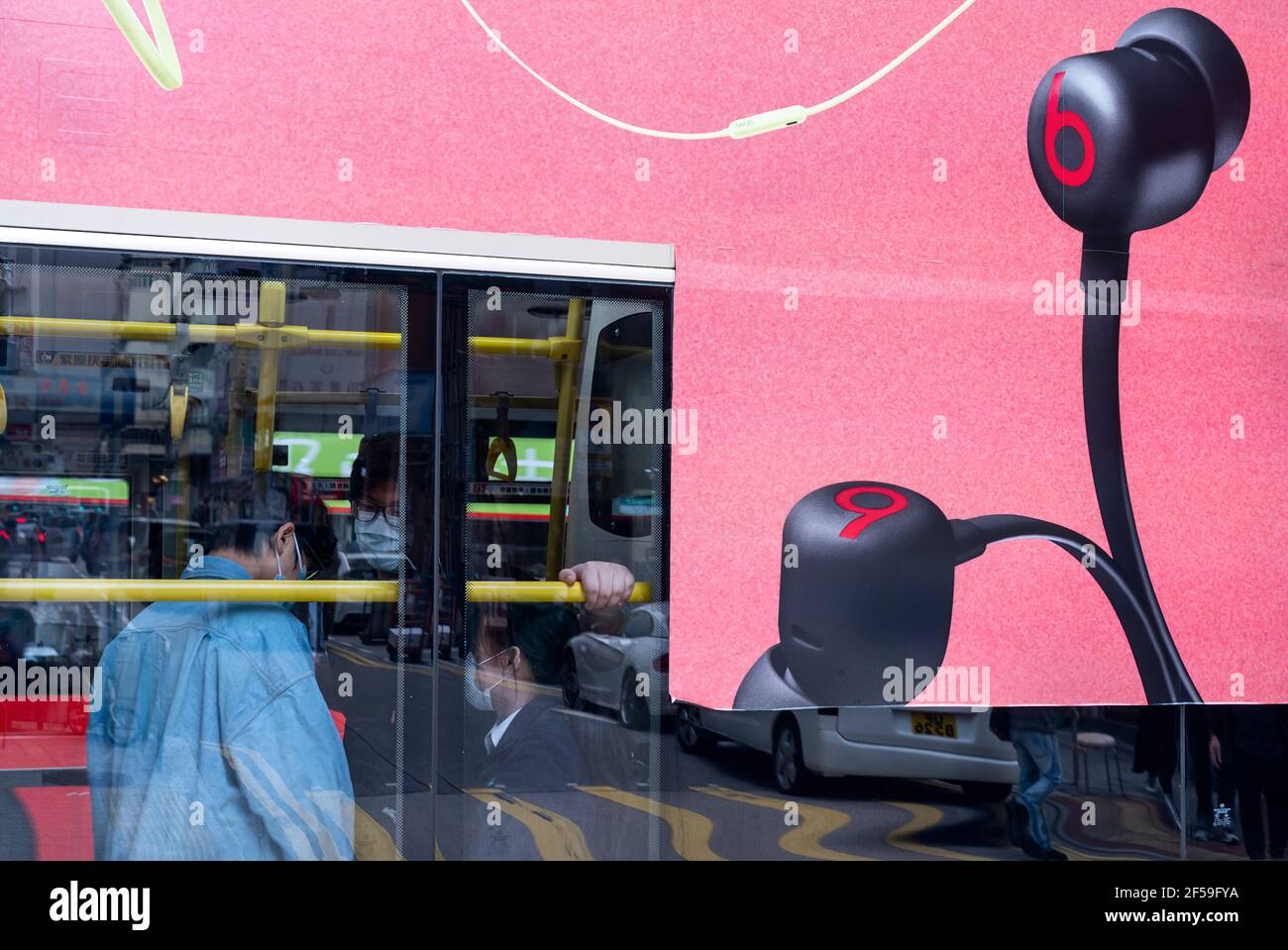 A bus displays a commercial ad of the American consumer audio products manufacturer brand Beats Electronics LLC, also known as Beats by Dr. Dre or simply Beats by Dre, in Hong Kong. Stock Photo