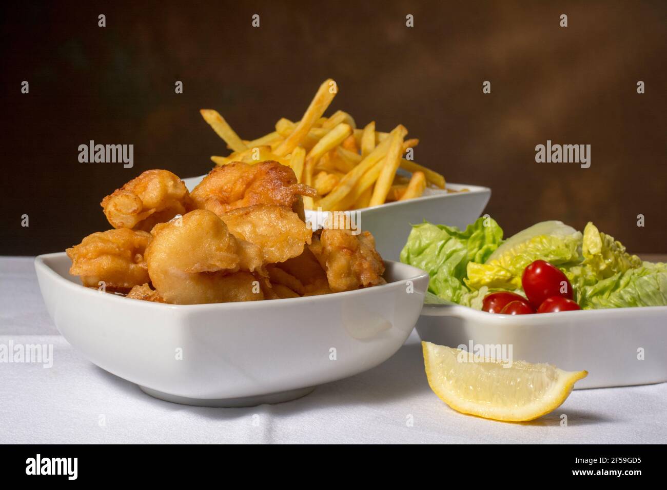 Deep fried scampi (prawns) in batter and chips with salad Stock Photo
